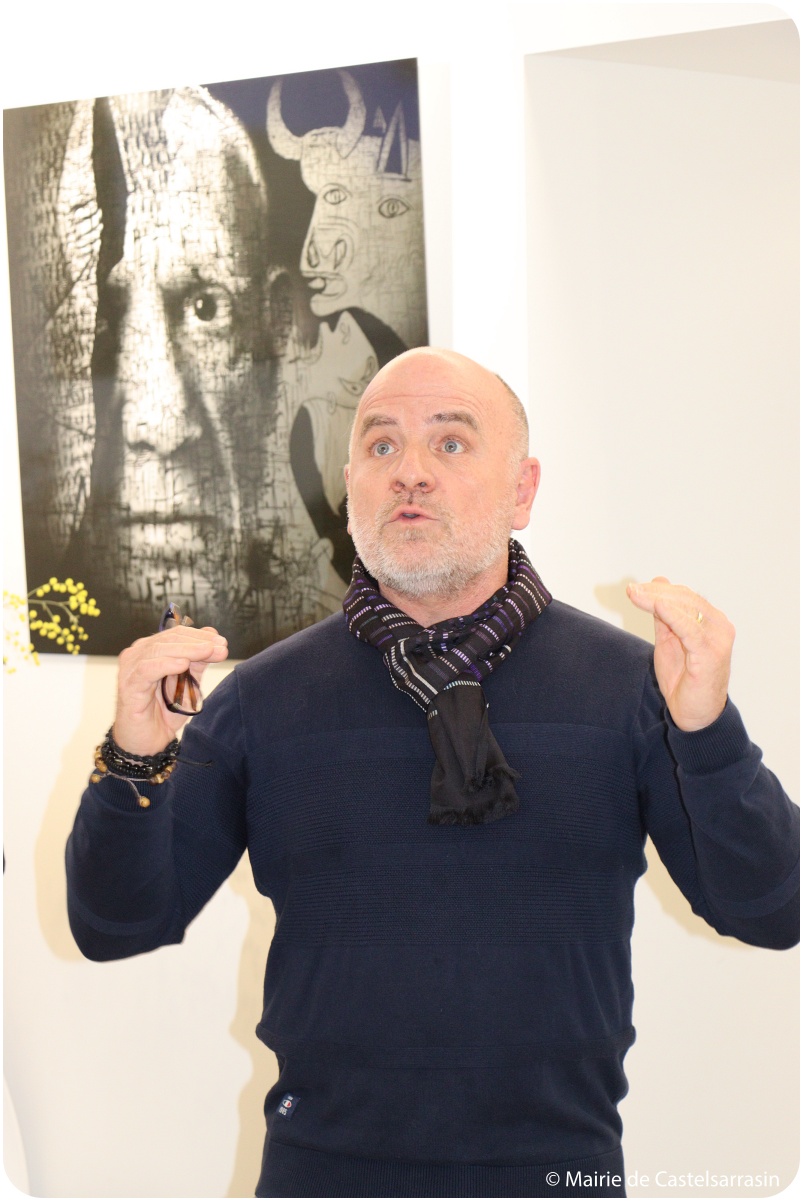 Philippe Viejo s'exprimant sur son exposition devant un portrait de Picasso