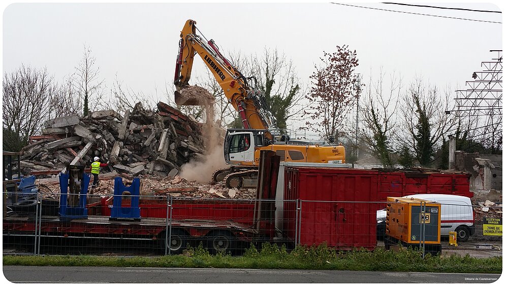 Le tractopelle déverse les briques démolies dans la remorque Le tractopelle déverse les briques démolies dans la remorque