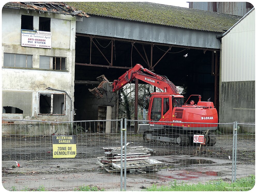L'engin de démolition s'attaque au hangar L'engin de démolition s'attaque au hangar