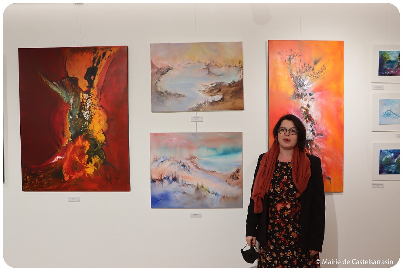 L'artiste Thésée devant 4 de ses tableaux L'artiste Thésée devant 4 de ses tableaux