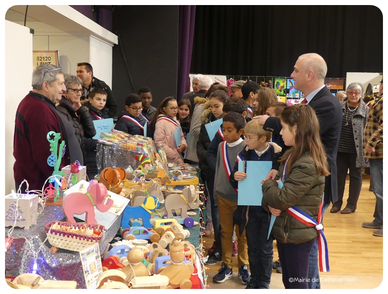 Les membres du CMJ et Monsieur le maire devant une étale de jeux en bois au marché de noël 2018