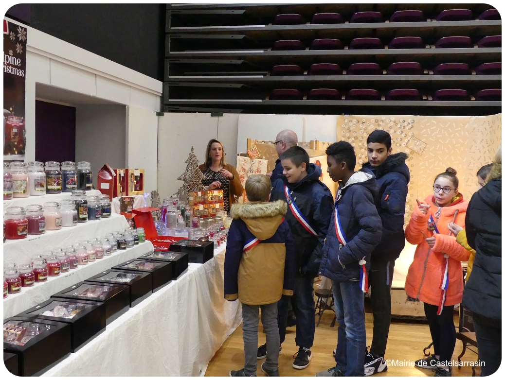 Les élus du CMJ et le maire devant un stand de bougie au marché de Noël